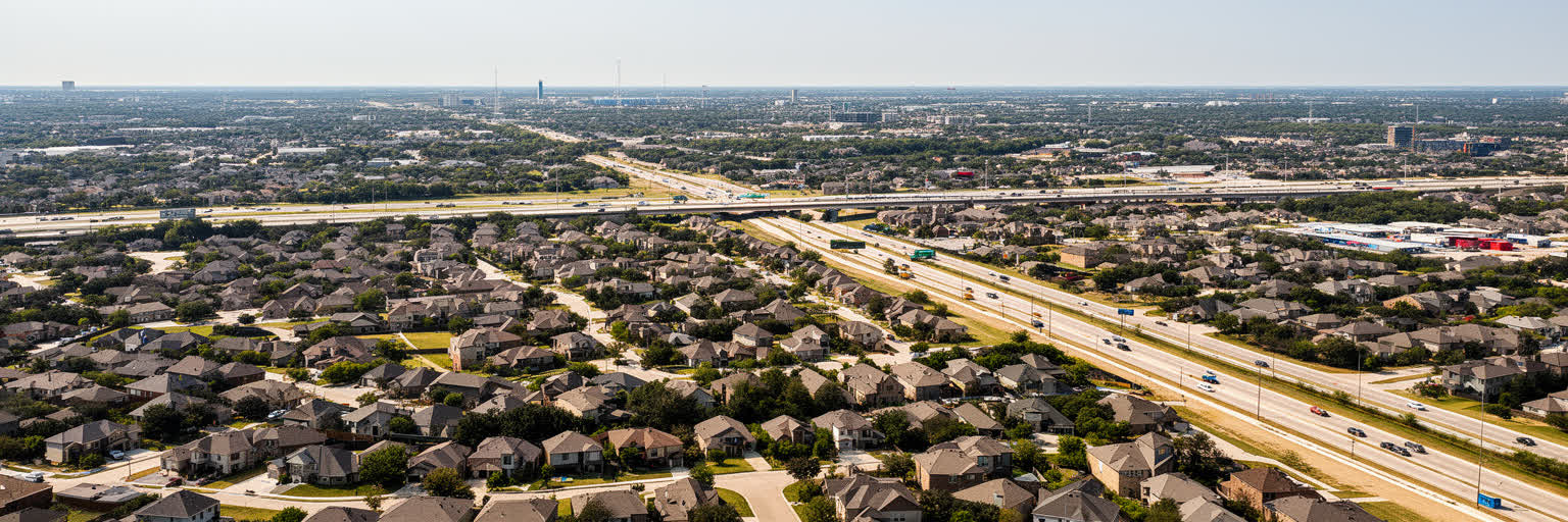 ダラス都市圏の郊外住宅地、学校区、高速道路、分譲地、ショッピングセンターが重なる住宅景観