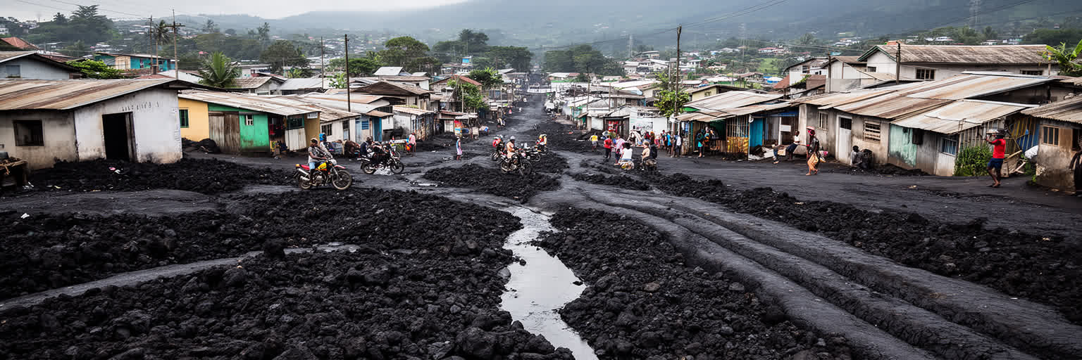 黒い溶岩の地面、住宅、排水路、市場、空港道路が重なるゴマの都市形態