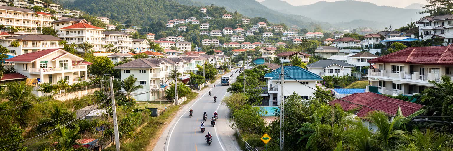 住宅開発、丘陵道路、学校、市場、バイク交通が重なるプーケットの日常