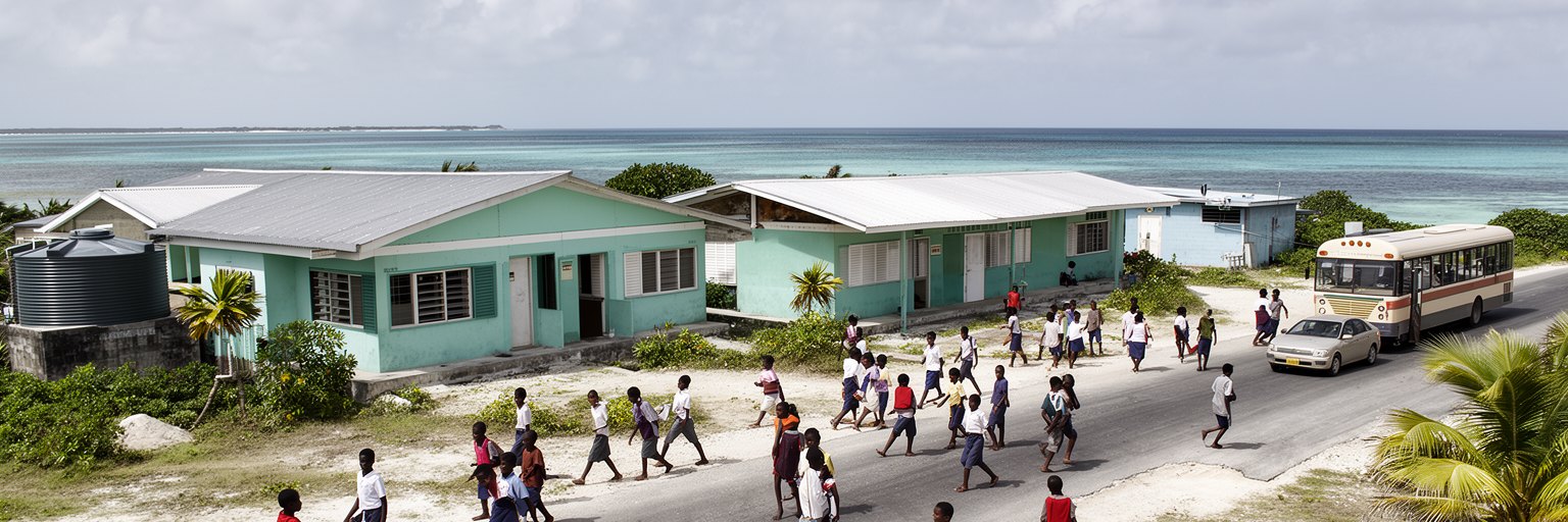 学校、学生、バス、海辺の通学路、職業訓練が重なるサウスタラワの若者の風景